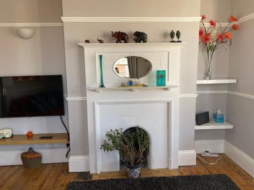 a living room with a fireplace with a mirror at Herne Bay Central - 2 minutes from beach apartment in Herne Bay