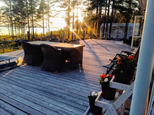 a patio with a table and chairs on a deck at Havsnära villa in Nordmaling