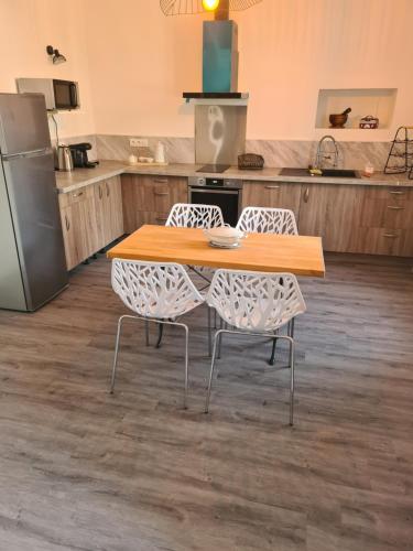 une cuisine avec une table en bois et deux chaises dans l'établissement Appartement rénové avec jardin, à Cuxac-dʼAude