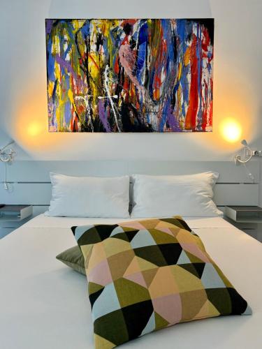 a bed with a painting on the wall above it at Residenza d'Artista al Conservatorio in Salerno