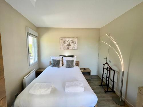 une chambre avec un grand lit blanc avec deux oreillers dans l'établissement PGH N18 - À 300m de la Plage avec Parking Privé, à La Grande Motte