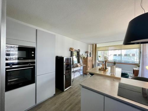 une cuisine avec des armoires blanches et des appareils noirs dans l'établissement PGH N18 - À 300m de la Plage avec Parking Privé, à La Grande Motte