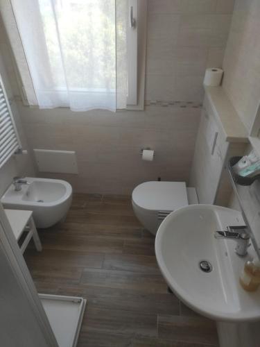 a bathroom with two sinks and a toilet and a window at Agriturismo Honey Farm in Piazzola sul Brenta