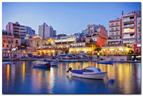 a group of boats in a harbor with buildings at Manoel De Vilhena Holiday Apartments in Il-Gżira