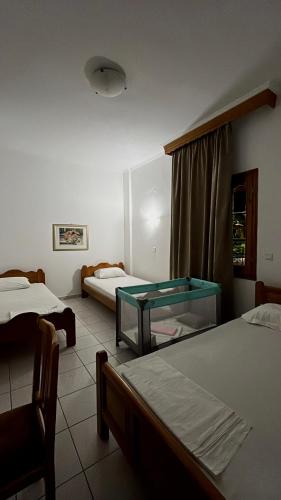 a room with two beds and a glass table at Mpoufidis Rock House Meteora in Kalabaka