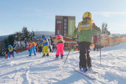 a group of children on skis in the snow at AHORN Hotel Am Fichtelberg in Kurort Oberwiesenthal