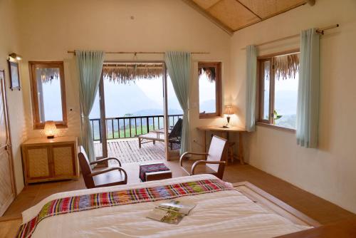 ein Schlafzimmer mit einem Bett und einem Balkon in der Unterkunft Puluong Retreat in Pu Luong