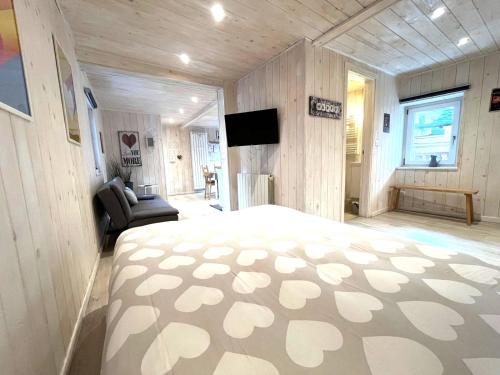 a bedroom with a bed and a couch and a television at Due cuori e... un Loft nel cuore antico di Aosta in Aosta