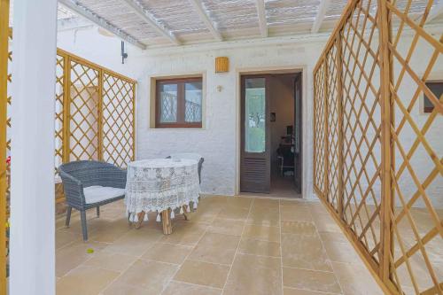 a patio with a table and a chair and a door at Masseria Casina Vitale in Ceglie Messapica