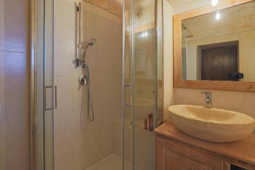 a bathroom with a sink and a glass shower at Masseria Casina Vitale in Ceglie Messapica