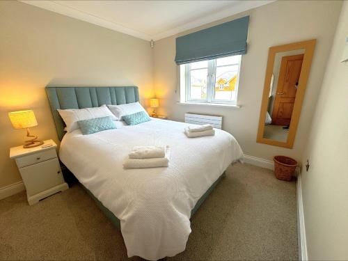 a bedroom with a large bed with towels on it at At Watersedge in Exmouth