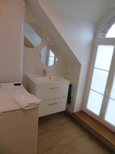 une salle de bain avec un lavabo et une fenêtre dans l'établissement Le Cèdre, à Cambron