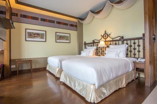 a hotel room with two beds with white sheets at Chankam Boutique Hotel in Chiang Mai