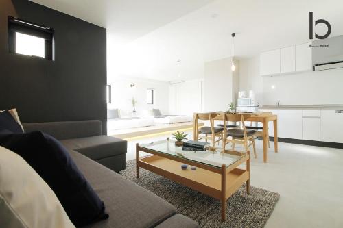 een woonkamer met een bank en een tafel bij bHOTEL heiwaodori, Room: 901 - Vacation STAY 17680v in Hiroshima