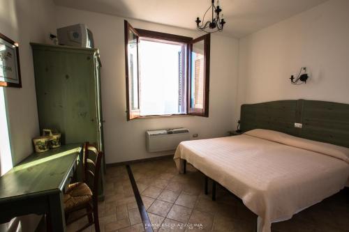 una piccola camera con letto e finestra di B&B Baglio Maragani a Maragani
