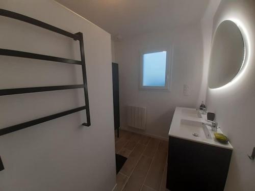 a white bathroom with a sink and a mirror at La Maison du Lividig 3 étoiles OT29 in Brignogan-Plages