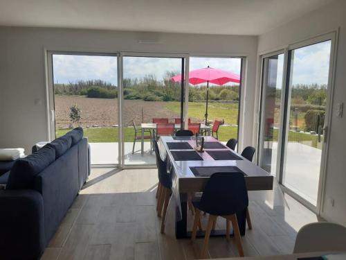 un salon avec un canapé et une table avec des chaises dans l'établissement La Maison du Lividig 3 étoiles OT29, à Brignogan-Plage