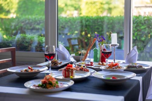 a table with plates of food and glasses of wine at Crystal Centro Resort - Ultimate All Inclusive in Lara