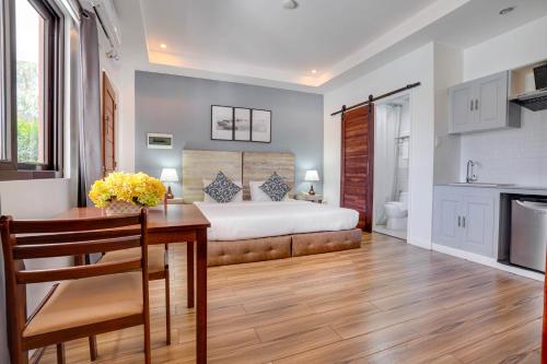 a bedroom with a bed and a table and a kitchen at The Mansion Boutique Hotel in Mabalacat
