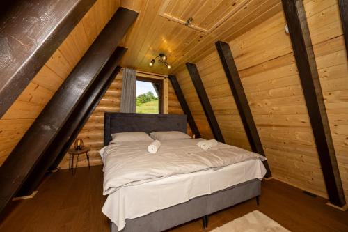 a bedroom with a bed in a log cabin at Kuća za odmor Sokolac in Brinje