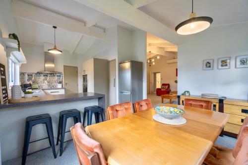 a kitchen and dining room with a wooden table and chairs at 27 on Henry - Te Anau Holiday Home in Te Anau
