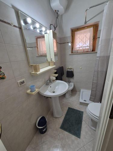 a bathroom with a sink and a toilet and a mirror at Villa Sabaudia in Sabaudia
