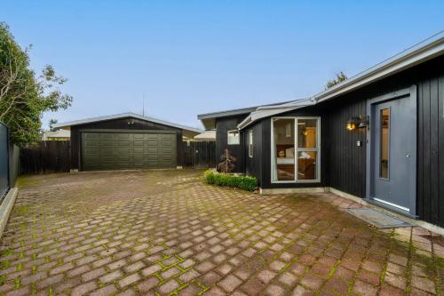 a house with a brick driveway in front of it at 27 on Henry - Te Anau Holiday Home in Te Anau