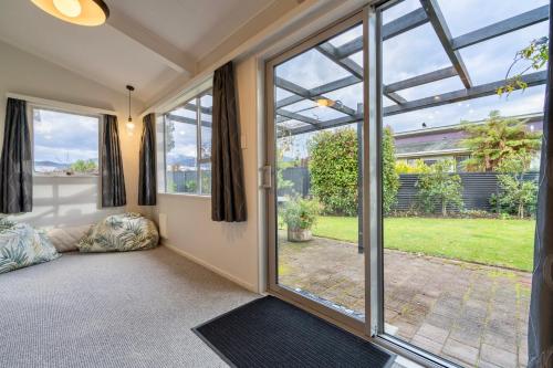 a living room with sliding glass doors and a view of a yard at 27 on Henry - Te Anau Holiday Home in Te Anau