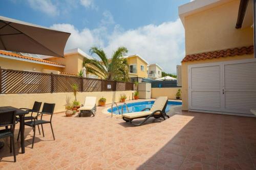 a patio with chairs and a pool in a house at Kisonerga Villa in Paphos in Kissonerga