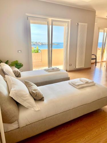 two beds in a room with a view of the beach at Seaside Suite in Civitavecchia