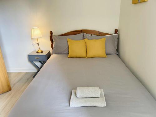 a large bed with yellow pillows in a room at Spacious City Centre flat free parking& superfast WIFI in Edinburgh