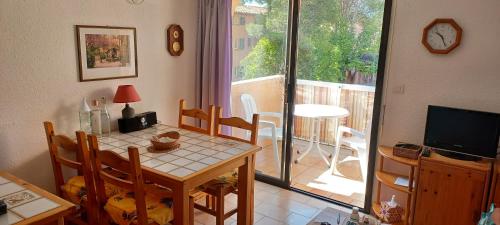 une salle à manger avec une table et une télévision dans l'établissement Appartement 2 pièces à Saint Aygulf-Fréjus, à Fréjus