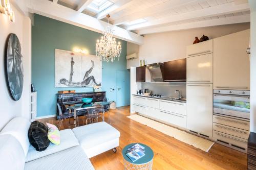 a living room with a white couch and a kitchen at Riflessi sul lago in Predore