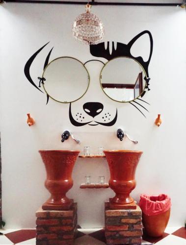 a wall with a picture of a cat wearing glasses at Mekong Pottery Homestay, Green-Friendly & Boat Tour in Vĩnh Long