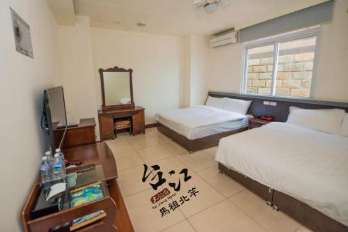 北竿鄉的住宿－台江大飯店，酒店客房,设有两张床和镜子