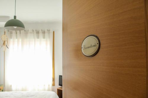 a bedroom with a wooden wall with a clock on the wall at Aliving Colo in Raxo