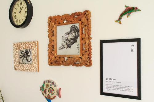 a wall with a picture and a mirror and a clock at Aliving Colo in Raxo