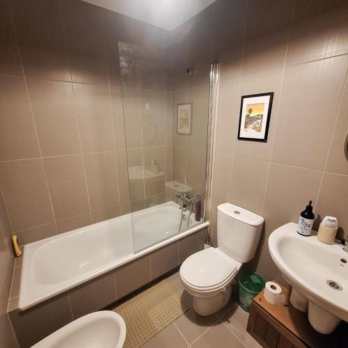 a bathroom with a toilet and a tub and a sink at Aliving Colo in Raxo