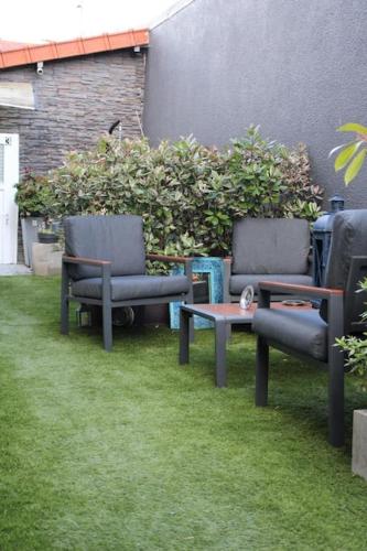 2 chaises et une table dans l'herbe dans l'établissement My House, à Choisy-le-Roi