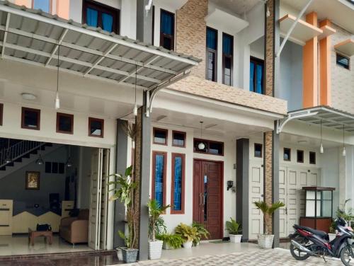a house with a motorcycle parked in front of it at An Nisa Homestay Syariah Aceh Mitra RedDoorz in Cotgirek