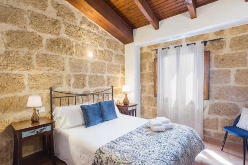 Un dormitorio con una cama y una pared de piedra. en Apartamento Jávea Pueblo, en Jávea