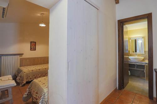 a room with two beds and a bathroom with a sink at Masseria Casina Vitale in Ceglie Messapica