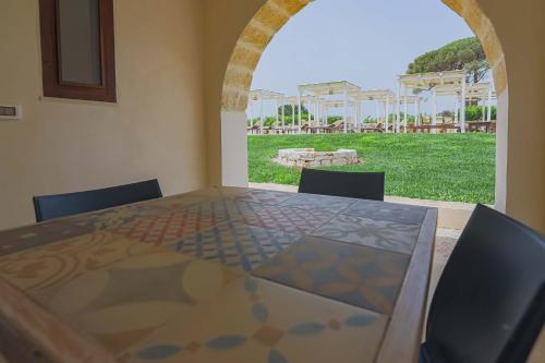 a table with chairs and a view of a yard at Masseria Casina Vitale in Ceglie Messapica
