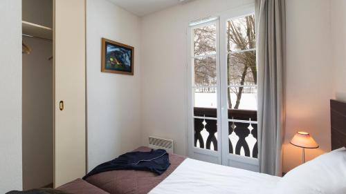 a bedroom with a bed and a window at Vacancéole - Les Jardins de Balnéa in Loudenvielle