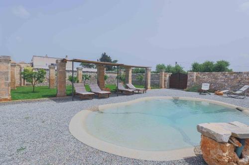 a small pool with a table and chairs in a yard at Masseria Casina Vitale in Ceglie Messapica