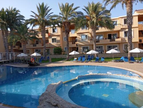 a large swimming pool in front of a hotel at Pagona Holiday Apartments in Paphos City
