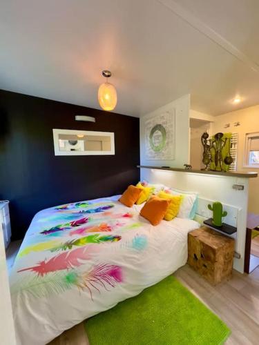 - une chambre avec un grand lit et une couette colorée dans l'établissement Charming Guesthouse on the Edge of Saint Germain en Laye Forest with Parking and Terrace, à Le Mesnil-le-Roi