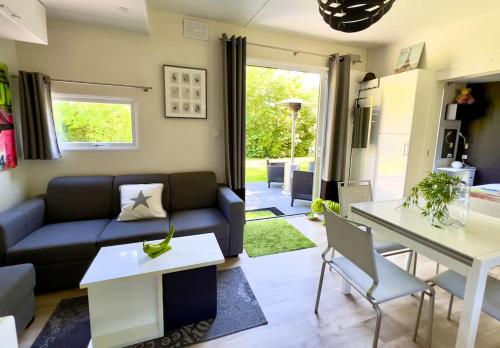 un salon avec un canapé et une table dans l'établissement Charming Guesthouse on the Edge of Saint Germain en Laye Forest with Parking and Terrace, à Le Mesnil-le-Roi