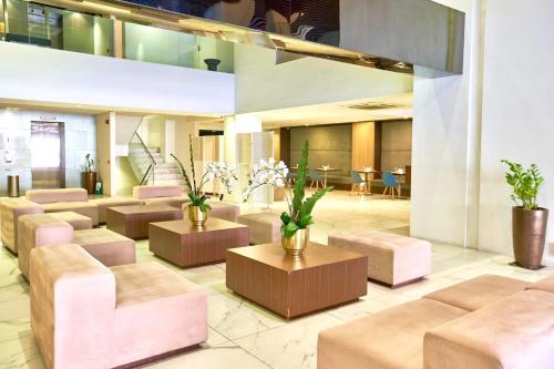 a lobby with a waiting area with couches and tables at Ramada Encore by Wyndham Makati in Manila