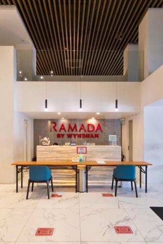 a large wooden table in a room with two chairs at Ramada Encore by Wyndham Makati in Manila